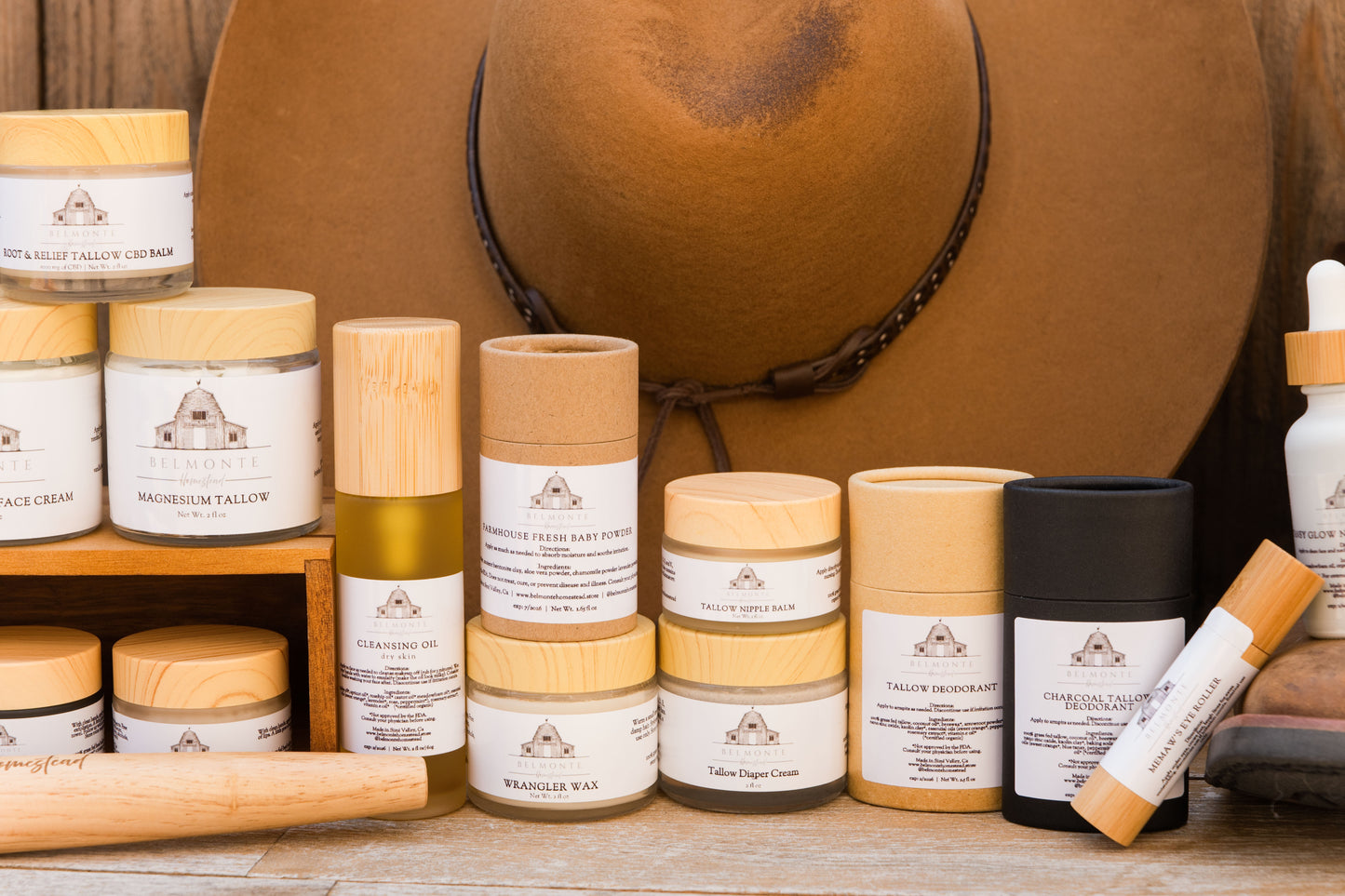 Collection of skincare products with a brown hat in the background