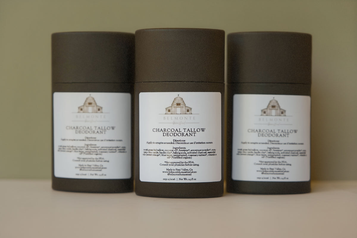 Three cylindrical containers of Charcoal & Tallow Deodorant on a neutral background